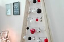 a light-stained frame Christmas tree with silver, white, red and black ornaments is a cool idea for a modern and contrasting space