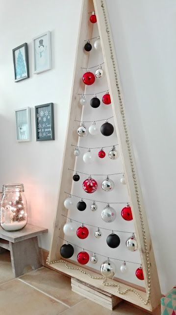 a light-stained frame Christmas tree with silver, white, red and black ornaments is a cool idea for a modern and contrasting space