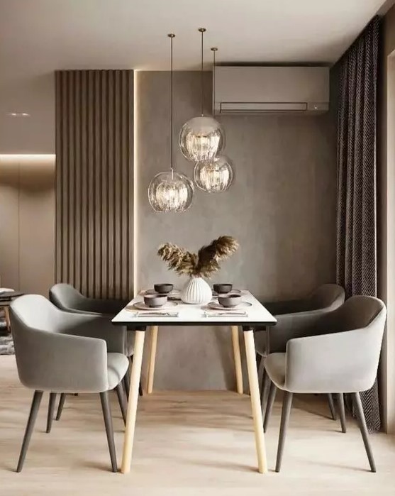 a lovely and welcoming taupe dining zone with taupe walls, paneling and curtains, a simple table and grey chairs plus pendant lamps