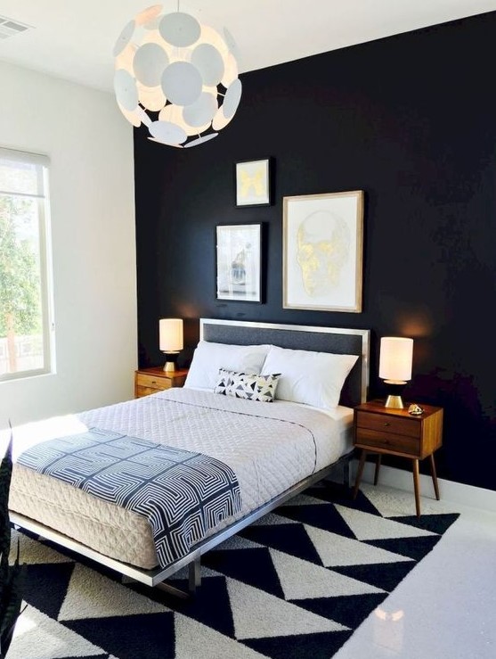 a mid century modern bedroom with a black accent wall, a polka dot lamp, a geometric rug and wooden nightstands