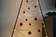 a minimalist frame Christmas tree lined up with lights, with gold and red beads and ornaments is a stylish idea