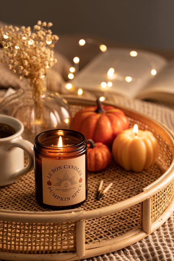 a rattan tray with a pumpkin spice candle, a pumpkin-shaped candle and some faux pumpkins is amazing for Thanksgiving