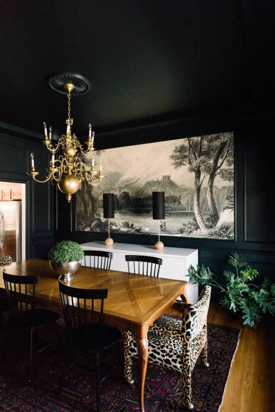 a refined black dining space with a mural, a chic stained table, black chairs, a leopard chair and a white credenza