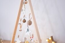 a small tabletop frame Christmas tree with yarn and clay star and ski ornaments is a cool and cute idea for the holidays