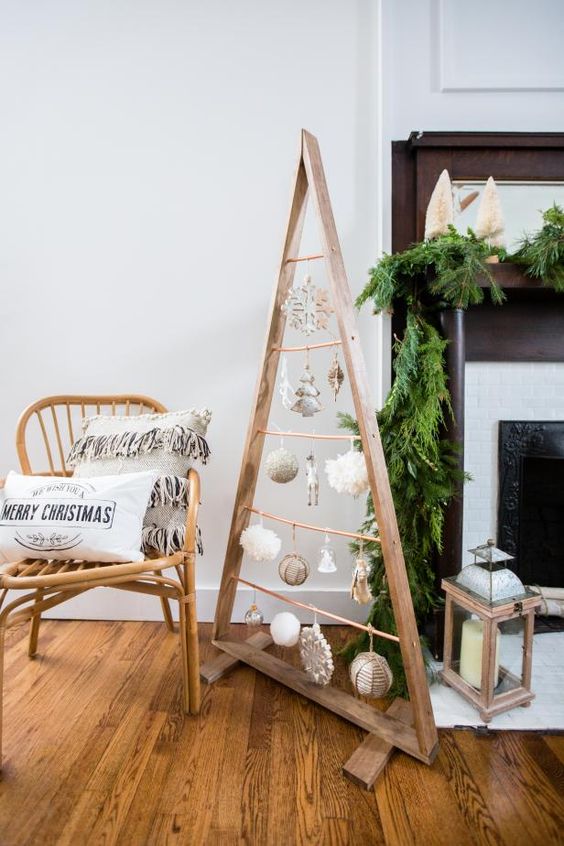 a stained frame Christmas tree with white, gold ornaments hanging on copper railing is a cool and fresh idea