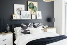a stylish Nordic meets boho bedroom with a gallery wall on a ledge, a black statement wall, sleek nightstands and a wicker lamp