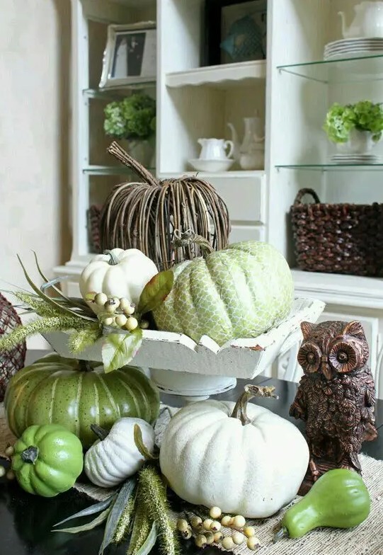 a vintage and rustic centerpiece with faux pumpkins in green and white and of vine is amazing for fall or Thanksgiving decor