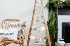 a wooden frame Christmas tree with white and silver ornaments hanging inside is a cool and cozy idea