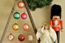an A-framed Christmas tree ornament display with colorful ornaments hangng in an irregular way looks very cool and fresh