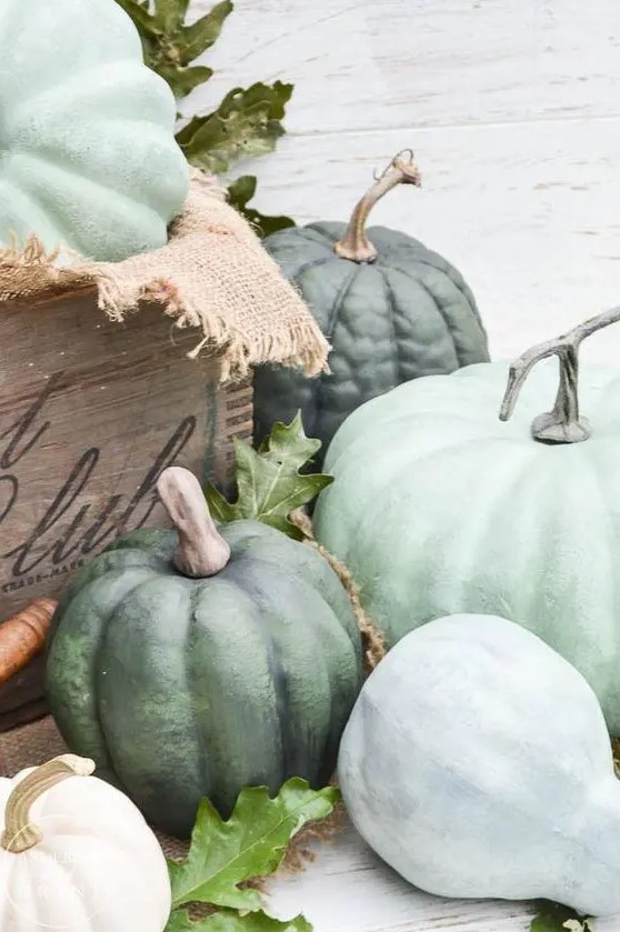 decorate your space with a crate filled with green heirloom pumpkins and some fresh foliage for simple rustic decor