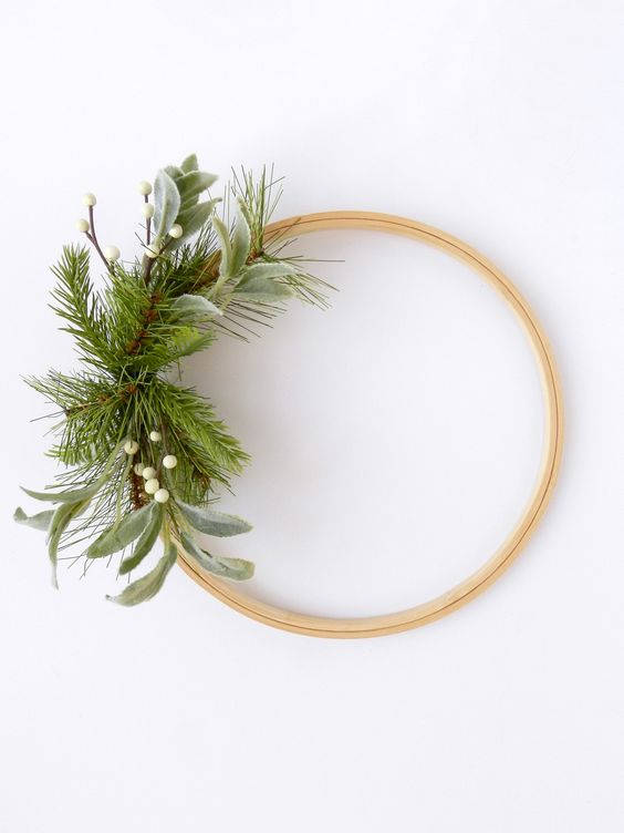 a minimal Christmas wreath with evergreens, greneery and berries is a stylish idea to decorate a holiday space