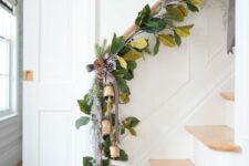 03 a beautiful leafy Christmas garland with snowy pinecones and bells is a stylish and out of the box idea of Christmas decor