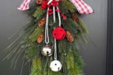 03 a bold Christmas swag with evergreens, pinecones, white, red and silver bells and a red and white plaid bow on top