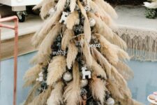 04 a Christmas tree decorated with pampas grass, metallic ornaments and calligraphy ones is a lovely boho decor idea