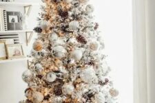 04 a breathtaking winter wonderland Christmas tree with white and silver ornaments, lights, pinecones and branches is a gorgeous idea