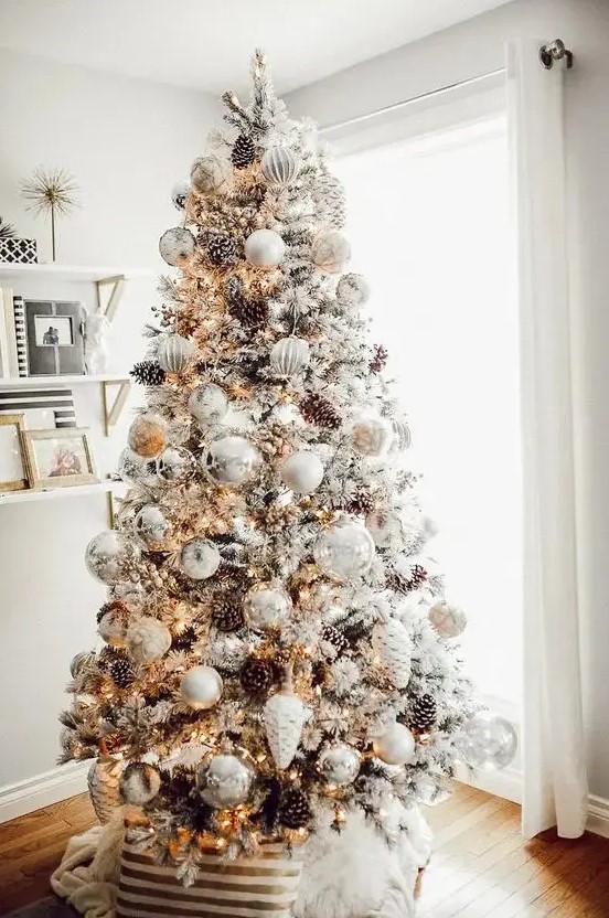 a breathtaking winter wonderland Christmas tree with white and silver ornaments, lights, pinecones and branches is a gorgeous idea