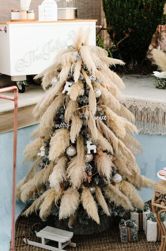 a Christmas tree decorated with pampas grass, metallic ornaments and calligraphy ones is a lovely boho decor idea