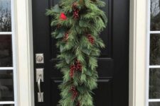 05 a classic Christmas swag of evergreens, red berries and a faux bird is a lovely idea for holiday decor