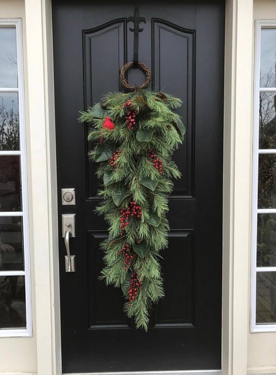 a classic Christmas swag of evergreens, red berries and a faux bird is a lovely idea for holiday decor