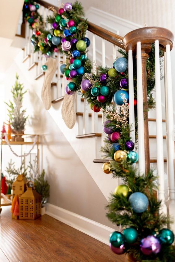 a colorful Christmas ornament with evergreens, gilded berries and knit stockings is a lovely and bold decor idea