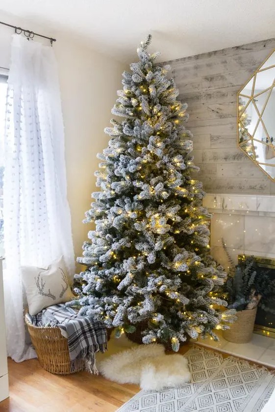 a flocked tree decorated with only lights for those who want maximize a natural feel and get a chic minimalist look