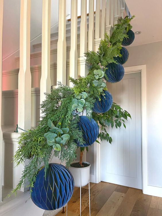 a eucalyptus and fir Christmas garland with paper blue baubles is a stylish and catchy way to decorate a banister