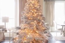 06 a large flocked Christmas tree decorated with only lights is a fantastic idea for winter wonderland feel in the space