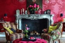 06 a lovely magenta vintage-inspired living room with a vintage fireplace, chic printed chairs and a hot pink ottoman, vintage artworks