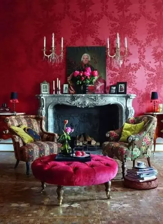 a lovely magenta vintage inspired living room with a vintage fireplace, chic printed chairs and a hot pink ottoman, vintage artworks