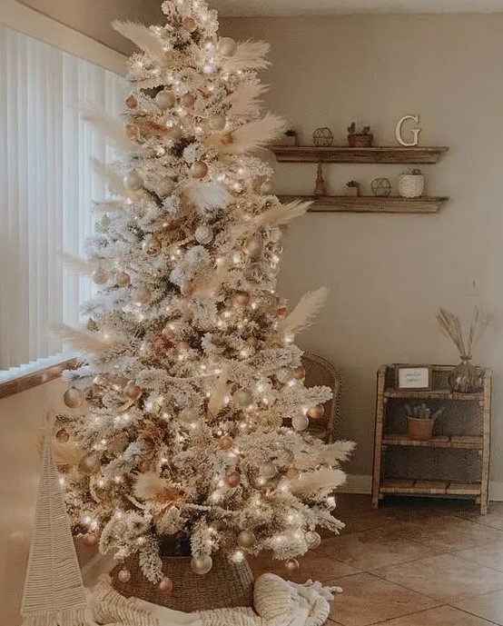 an amazing neutral boho Christmas tree decorated with pampas grass, gold and metallic ornaments, white ones and lights