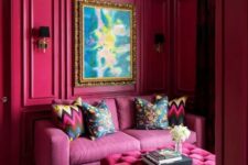 07 a magenta space with a pink sofa, a hot pink ottoman, a black crystal chandelier and a statement artwork is amazing