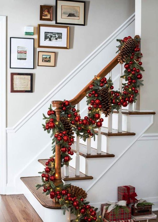a gorgeous evergreen Christmas garland with red ornaments, lights and oversized pinecones will make a gorgeous statement in the space