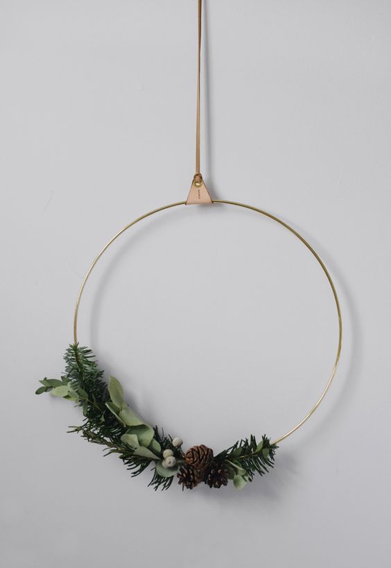 a minimalist Christmas wreath with evergreens, foliage, berries and pinecones is a stylish decor idea for a minimalist home