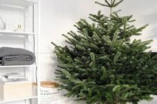09 a minimalist Scandinavian Christmas tree with no decor and only faux fur to cover the base is a gorgeous idea to rock