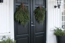 09 all-natural Christmas front door decor with evergreen swags, some evergreens on the floor and in pots