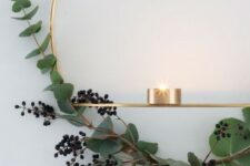 10 a gold wreath with privet berries and eucalyptus and some candleholders for a stylish minimalist space