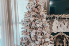 10 a neutral boho Christmas tree with creamy and pink ornaments, wooden beads, pampas grass and fronds and lights