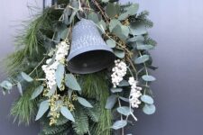 10 an evergreen Christmas swag with foliage, wihte berries, moss and a large bell is a lovely front door decor idea