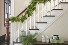 12 a lush and textural greenery garland on the railing and some branches in a vase are a nice combo for natural Christmas decor