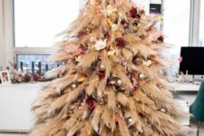 12 a pampas grass Christmas tree with neutral, pink and burgundy blooms and metallic ornaments plus lights