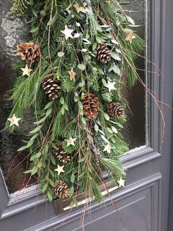an evergreen Christmas swag with leaves, pinecones, branches and pinecones plus some stars is amazing for outdoors