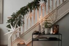 13 a lush evergreen garland paired with white paper stars is a stylish and bold decor idea for Christmas