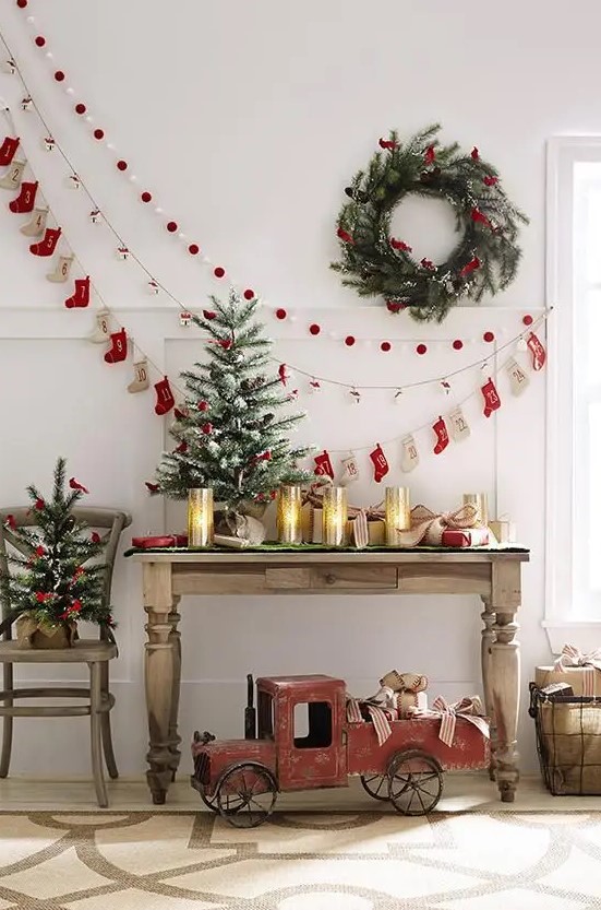 a pompom, paper house and decorative stocking garland plus a wreath on the wall can be a nice idea for a vintage space