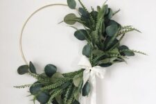 14 a cool modern Christmas wreath with several types of greenery attached only on one side, with a white ribbon bow