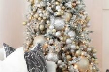 14 a snowy Christmas tree with oversized and smaller metallic Christmas ornaments plus lights