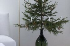 15 a Christmas tree in a dark green bottle with white candles and a star is a stylish minimalist idea