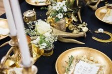 15 a gorgeous black and gold table setting with candles, antlers, gold chargers, white blooms and greenery