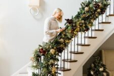 15 a sophisticated evergreen banister garland with gold ornaments, lights, soem faux blooms and metallic ornaments