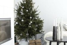 16 a Christmas tree with silver and clear ornaments and an arrangement of black and white candleholders for a Nordic feel