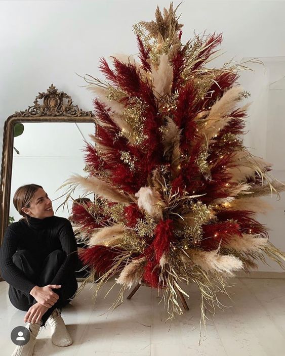 a super bold neutral and burgundy pampas grass Christmas tree decorated with gilded branches and lights is cool for the holidays